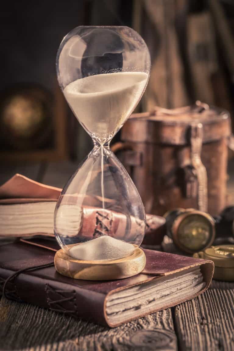 Aged hourglass and journal as a concept of journey diary