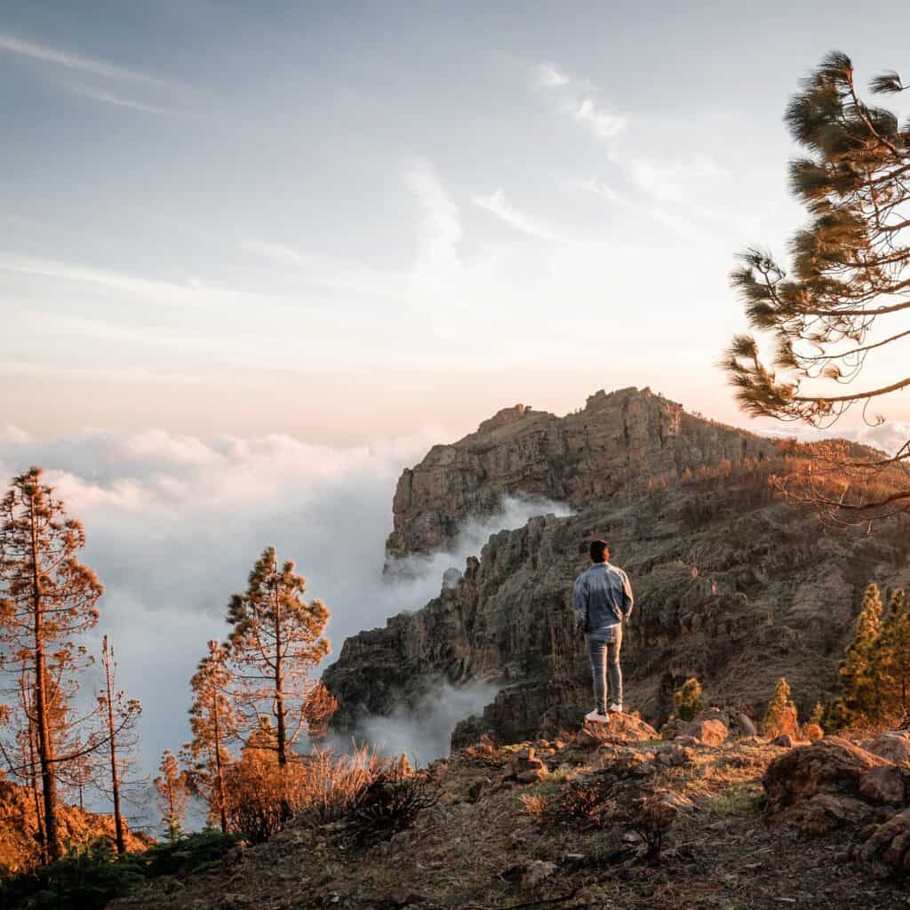 Young man enjoying sea of clouds sunset among the mountains